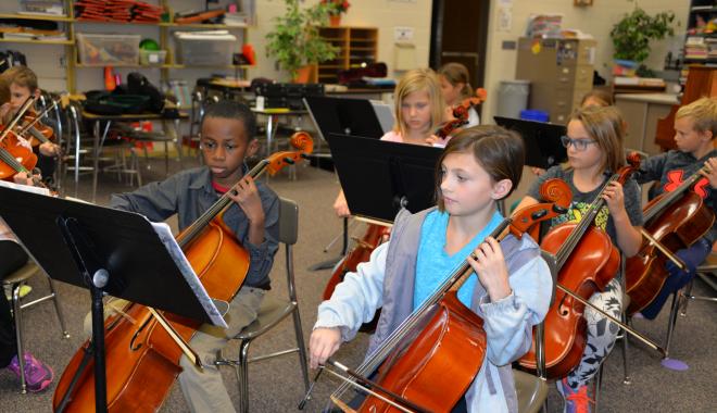 Orchestra students playing cellos 