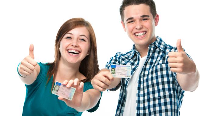 Two high school students showing their drivers license