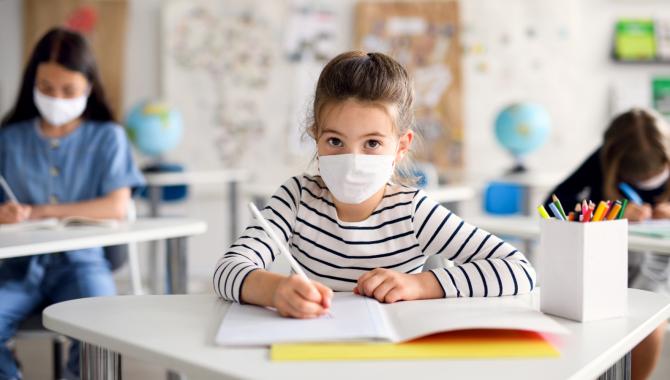 Child at desk wearing mask