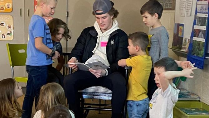 BHM student volunteer reading to 2nd graders