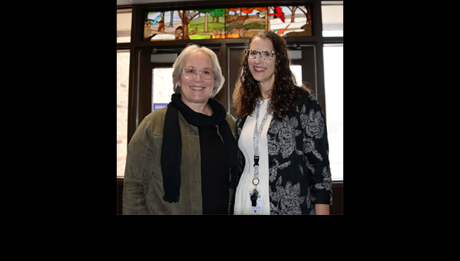 Artist and teacher standing under stained glass