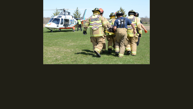 Firefighters carry a mock crash victim to a helicopter.