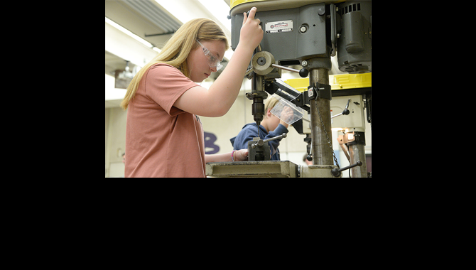 Student running a drill press