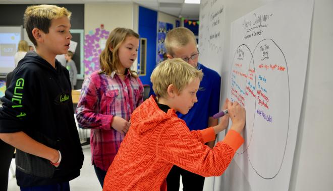 kids writing on a white board
