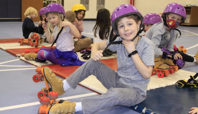 student putting on helmet for rollerskating