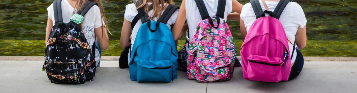 Students sitting with backpacks on