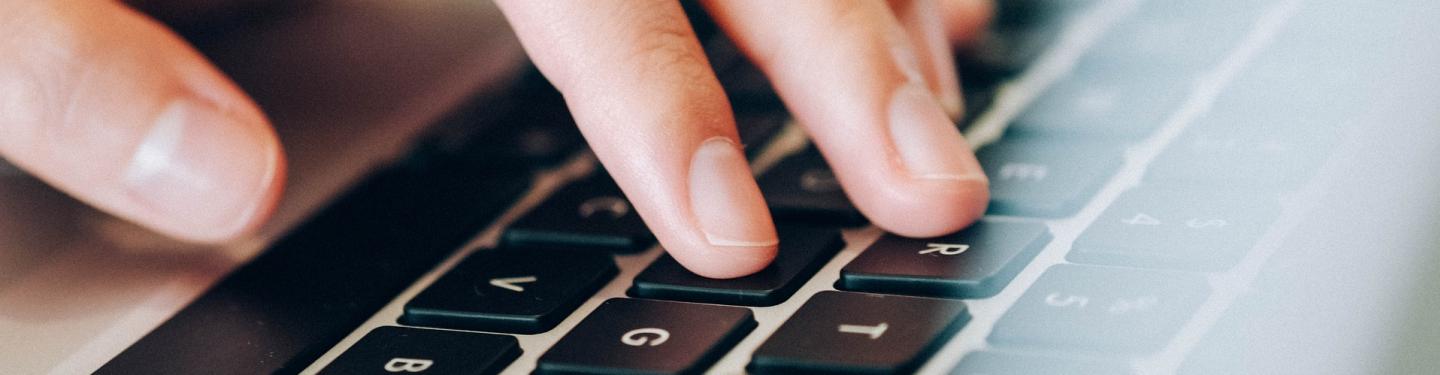 fingers on laptop keyboard
