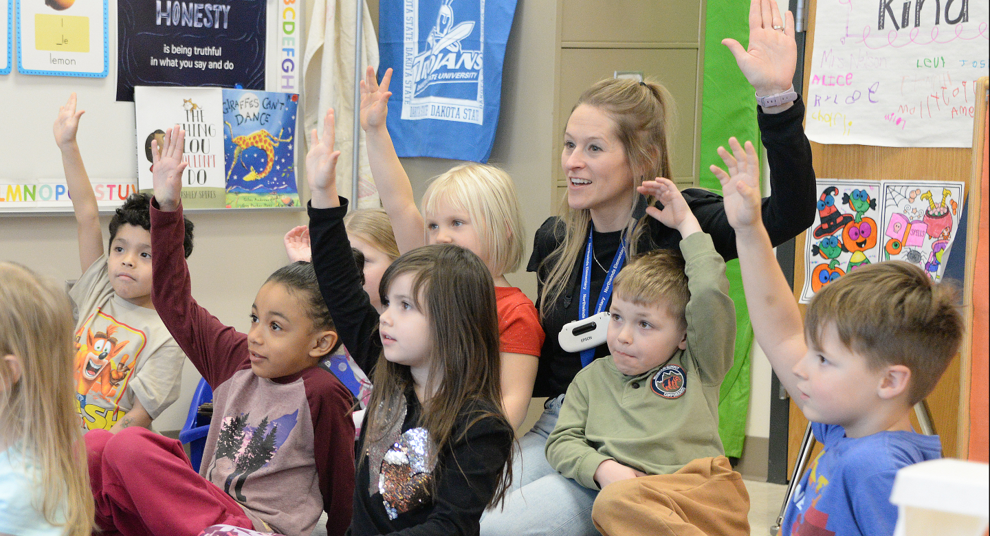 Teacher and students raising their hands