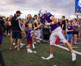 Football player greeting kindergartner