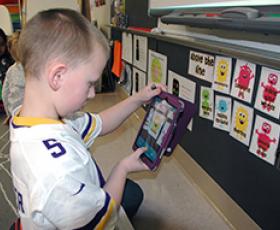 1st grader with iPad using learning apps