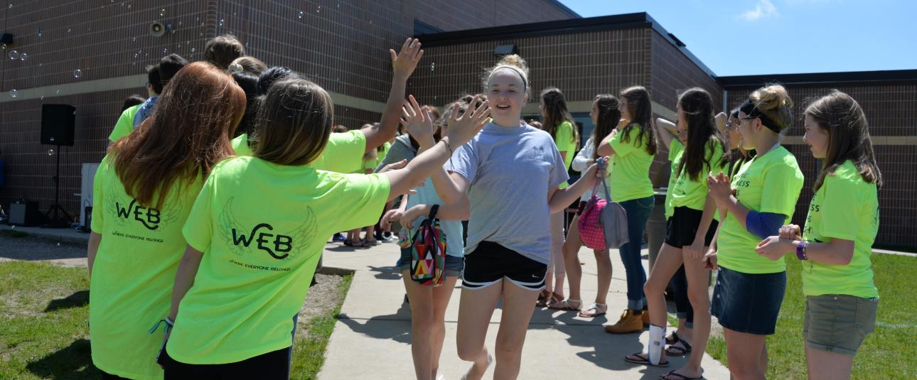 Student high fiving outside