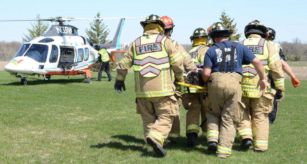 Firefighters carry a mock crash victim to a North Memorial helicopter.