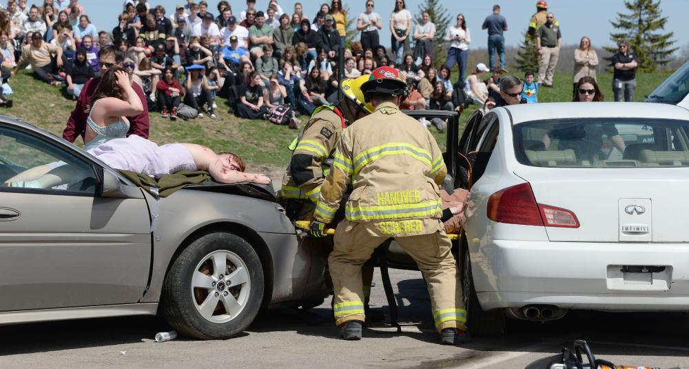 Firefighters extricate a mock crash victim trapped in a vehicle.