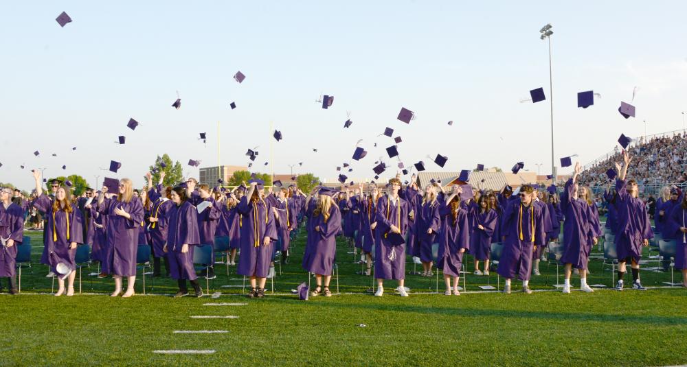 Graduates throw their caps