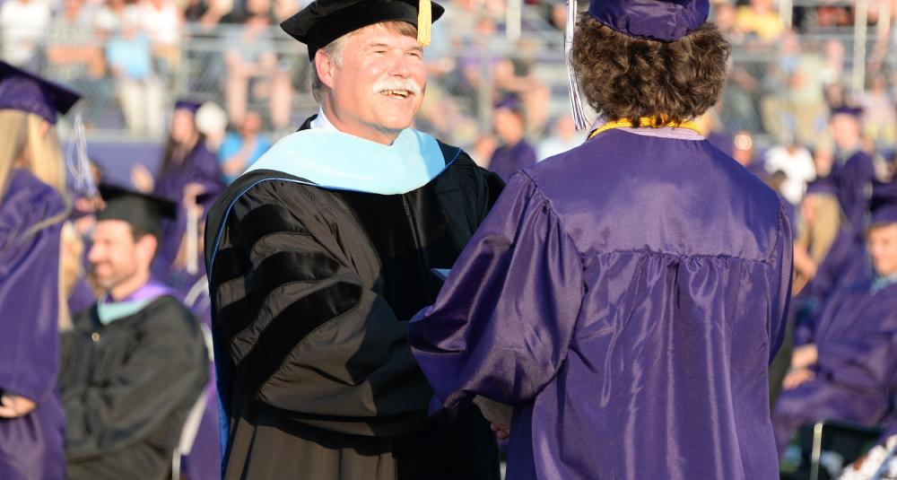 Superintendent congratulates a graduate