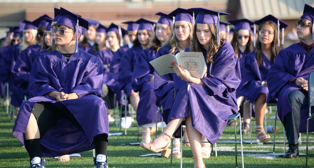 Graduates read the program